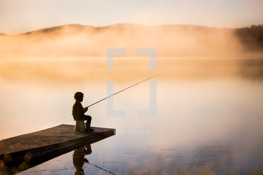 a boy fishing on a pier 