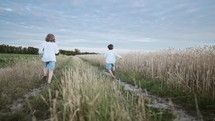 Little happy children boys running race outside city, natural rural landscape