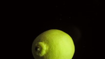 Round fresh juicy lemon plunging into water 