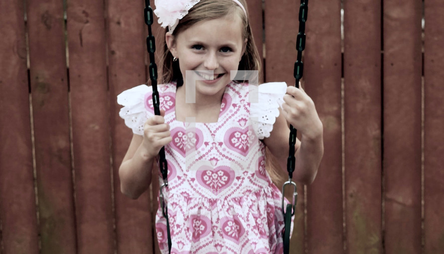 little girl on a swing set 