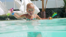 A happy wet little girl in pool 