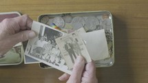 a man looking at old memories in a tin 