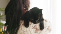Black Cat On Woman's Shoulder Inside The House. - close up shot