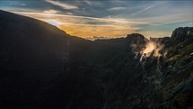 time-lapse of steam rising from a mountain at sunrise 