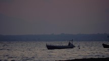 Evening scene of sea with moored boat rocking on waves