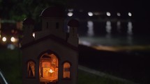 Miniature of Greek Orthodox church on sea-front at night