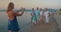 Big family walking on beach and taking pictures