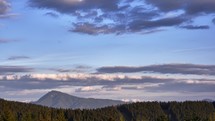 Hilly mountain scenery. Clouds forming over the mountain on the horizon. Pastel colored clouds, TIMELAPSE, 