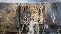 Water cascading from an ancient stone fountain
