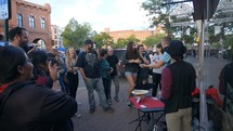 Street magicians entertaining a crowd on a city sidewalk