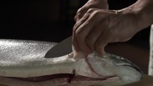 Chef cutting salmon