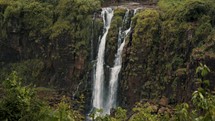 Waterfalls Flowing Through Mossy Cliffs. - wide shot