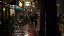 People walking downtown on a rainy night
