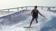 a woman wake boarding in a wave pool 
