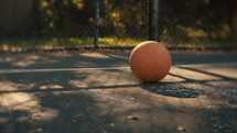 Close up of a basketball on an outdoor basketball court on a sunny day