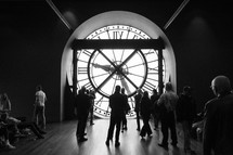 People standing and admiring the inside of a clock at the Orsay Museum in Paris, France