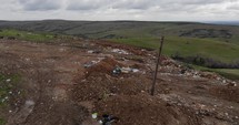 Rubbish Dump Area With Scenic Green Mountain View At Background. - Aerial Drone Shot