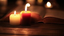 flickering candles and an open Bible 