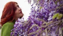 Woman under Purple Wisteria Flowers