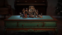 CGI Colorful Christmas Nativity set on coffee table. Including Baby Jesus, Mary, Joseph, the three Wisemen, a shepherd, an angel, and animals.