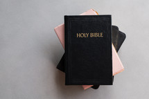 Holy Bibles stacked on a simple background with copy space