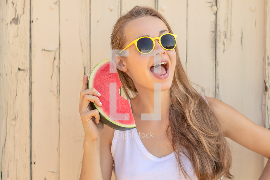 a teen girl holding a watermelon 