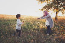 mother and son picking flowers in a field 