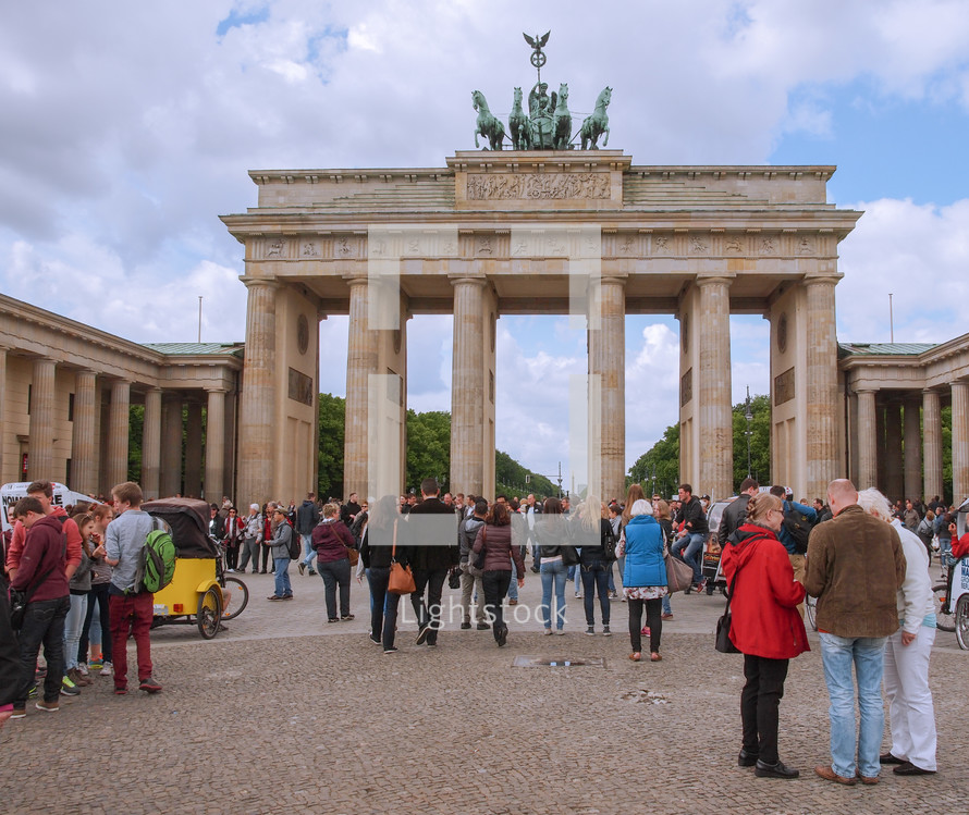 BERLIN, GERMANY - MAY 10, 2014: Tourists visiting the Brandenburger Tor (Brandenburg Gate) linking East and West Berlin