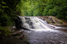 Waterfall in forest cascading down rocks slow shutter speed horizontal