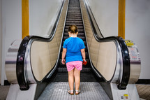 girl child approaching an escalator 