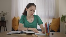 Teenage girl sitting at home preparing homework for school
