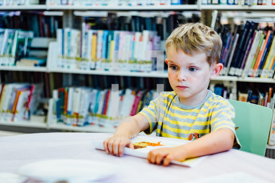 a boy reading in a library 