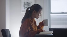 a young woman reading a Bible over coffee 