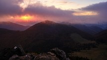 Sunrise in the mountains, clouds spill over the peaks of hills in the Carpathian mountains,timelapse.