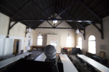 a microphone in front of a room of tables 