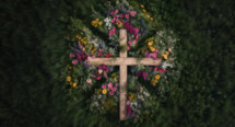 Wooden cross from an aerial perspective with wildflowers surrounding