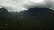 Aerial drone view of highlands of Scotland UK, river, mountains and stormy clouds in the background