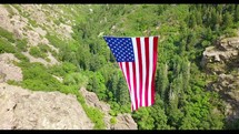 American flag on rope between mountains 