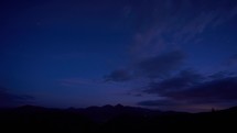 Silhouette of a mountain landscape under the night sky at dusk, the first stars in the sky