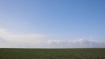 Wind Farm - Wind Turbines On A Green Field On A Sunny Day. wide shot