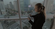 Businesswoman using touch pad by the window