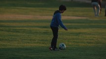Children kicking a football to each other in the park