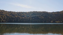 Abundant Nature With Autumnal Forest And Mirror Reflection On Lake Saint Ann In Romania. Pan Left, Right