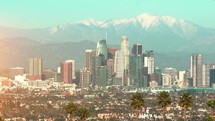 Los Angeles Downtown financial and business towers skyscrapers skyline and mountains in the background, California, 4K. Los Angeles skyline over snowy mountains