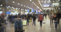 Defocused shot of people walking inside in an airport.