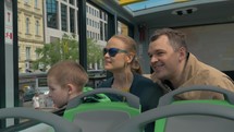 Family with child traveling around Vienna by double-decker bus