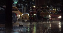 Road traffic under the rain in night city