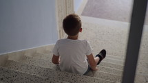 Kid sitting alone on the stairs
