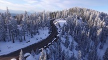 aerial view above a road through a winter forest 