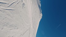 Vertical panorama of frozen winter mountains in beautiful sunny day with ski prints in fresh snow